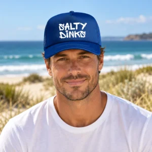 Salty Dinks Logo Trucker Cap shown in a coastal lifestyle setting