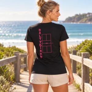 Salty Dinks Performance court Tee โ Womens shown in a coastal lifestyle setting